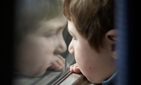 Bored young boy looking out of a window