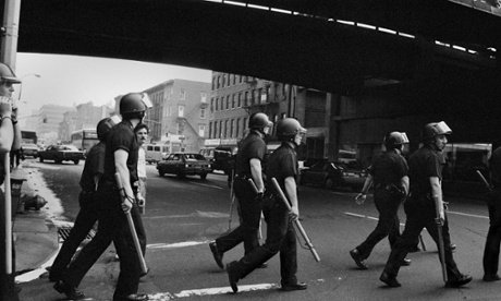 Riot police cross a street in 80s New York
