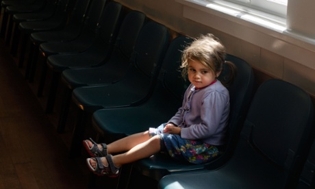 young girl sitting on chair looking anxious