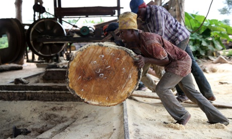 Labourers roll a log into a milling machine at a sawmill in south-west Nigeria.