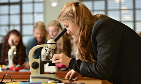 School girls using microscopes during a science lesson