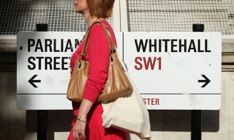 Woman walking past a street sign for Whitehall