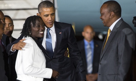 Kenyan president Uhuru Kenyatta, watches as Barack Obama hugs his half-sister, Auma Obama, after arriving in Nairobi.