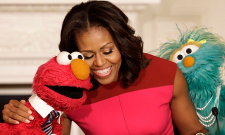 Michelle Obama hugs PBS Sesame Street characters Elmo and Rosita