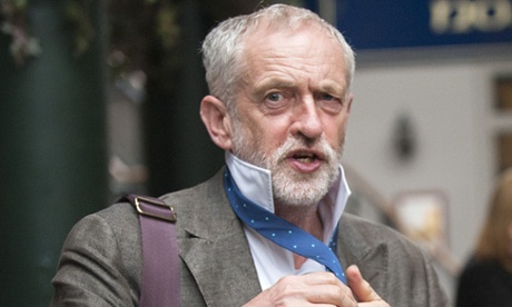 Labour party leadership contender Jeremy Corbyn poses for pictures with a tie given by a charity worker as he arrives to address a public rally in Glasgow, Scotland.