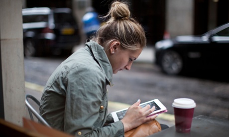 A woman works on her iPad at a cafe off Oxford Street