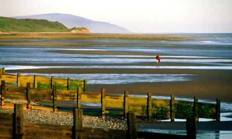 A couple walk on the beach at St Bees Head, near Workington, Cumbria.