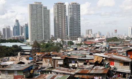 Slums are seen with the skyline of Makati, Manila's financial district, in the background.  