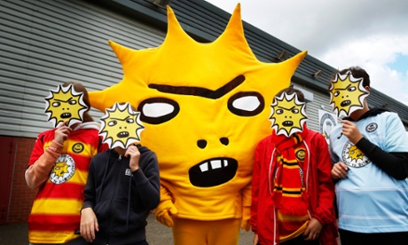 Fans hold up Kingsley masks
