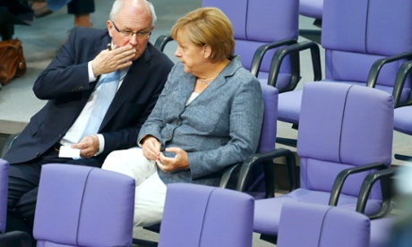 Volker Kauder, parliamentary faction leader speaks with German Chancellor Angela Merkel, prior to a vote on Greece's third bailout programme.