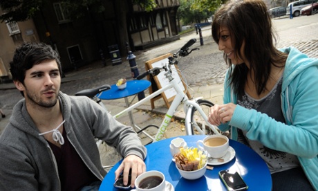A couple enjoy a coffee with their bikes nearby