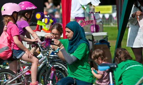 Volunteers help two children with their bikes