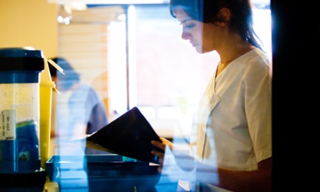  a nurse consults patient notes.