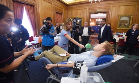 George Byczynski of the British Poles Initiative, who organised the #polishblood campaign donates blood as he is interviewed by reporters.
