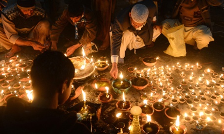 Devotees light candles at the shrine of Muslim Sufi Saint Data Ganj Bakhsh in Lahore. Photograph: AFP/Getty Images