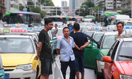 Taxi drivers driving vacant taxis in queues cause traffic jams on a road in Wuhan city, central China, as part of a protest against Uber.