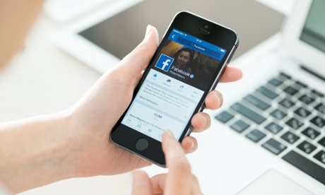 A woman using the Facebook app on her phone