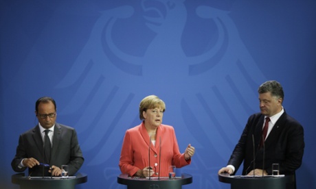 French President Francois Hollande, left, German Chancellor Angela Merkel, centre, and Ukrainian President Petro Poroshenko brief the media during a meeting at the chancellery in Berlin, Monday, Aug. 24, 2015.