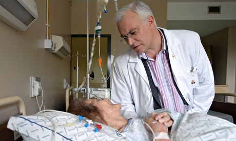A doctor next to a patient's bed in hospital