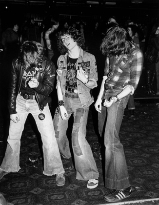 Metalheads playing air guitar at an Iron Maiden concert in 1980.From Street Culture: 50 Years of Subculture Style by Gavin Baddeley is published by Plexus Publishing