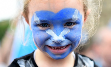 A young girl with a Scottish Saltire painted on her face waits outside a 'Yes' campaign rally in Glasgow, Scotland September 17, 2014.