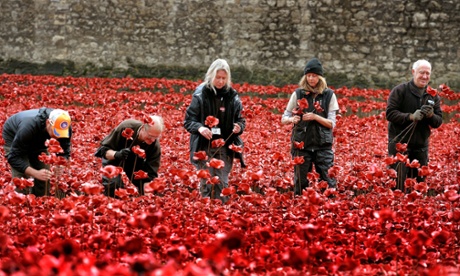 Volunteers remove poppies from the moat of the Tower of London, as work begins dismantling the 'Blood Swept Lands and Seas of Red' installation. Photograph: John Stillwell/PA