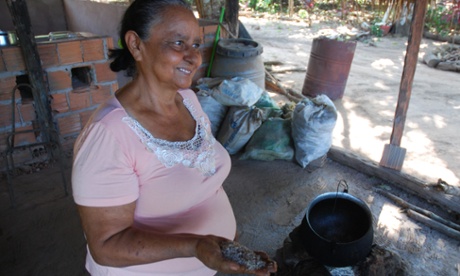 Emilia Alves da Silva Rodrigues in her backyard in Tocantins holding ground babassu seed kernels.