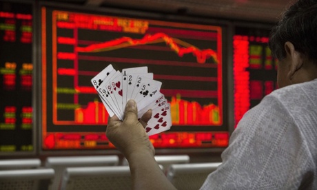 Two ways to gamble. A Chinese day trader plays cards in front of a stock ticker at a local brokerage house in Beijing, China.