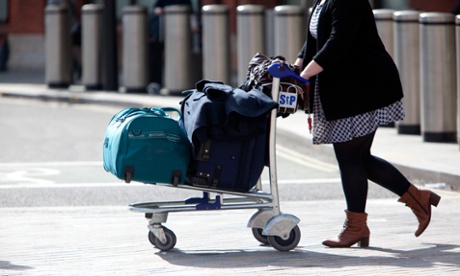 woman wheeling suitcase on trolley