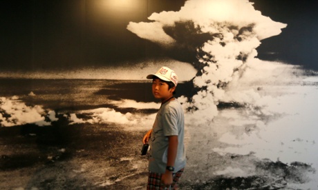 A boy walks past a huge picture showing the explosion of the atomic bombing on Hiroshima, at the Peace Memorial Museum in the Peace Memorial Park of Hiroshima, western Japan.