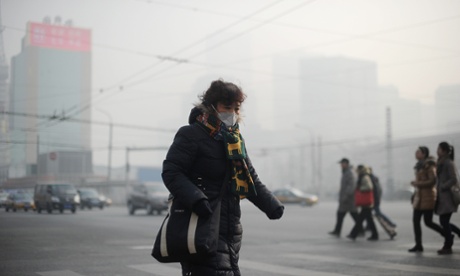 A  woman wearing a face mask makes her way along a street in Beijing