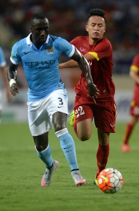 Manchester City's Bacary Sagna (L) and Vietnam's Vo Huy Toan at My Dinh stadium in Hanoi, July 2015.