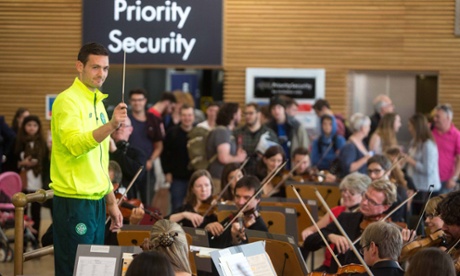 Queen's Celtic keeper Craig Gordon leads a performance of the Royal Scottish National Orchestra at Glasgow Airport, before flying out to Azerbaijan. Obviously.