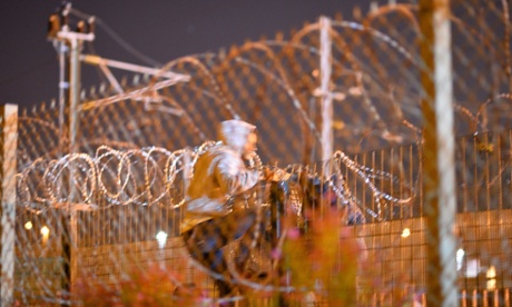 Migrants camped out in Calais, attempt to climb a security fence near refugee camp of Calais