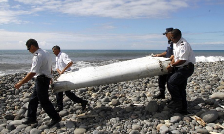 Officers carrying a flaperon from MH370.