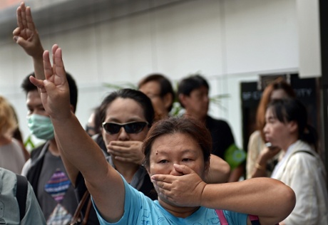 Opponents of Thailand's military coup are risking arrest by flashing the three-finger salute from the 