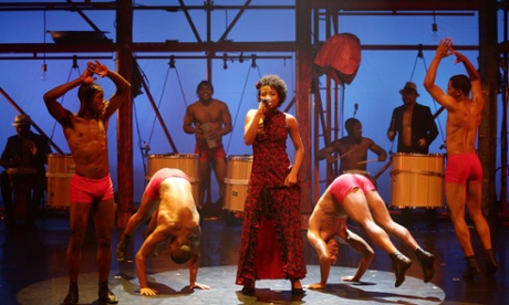 Dancers from Brazilian dance company Bale de Rua perform somersaults next to vocalist Alexia Falcão Lope