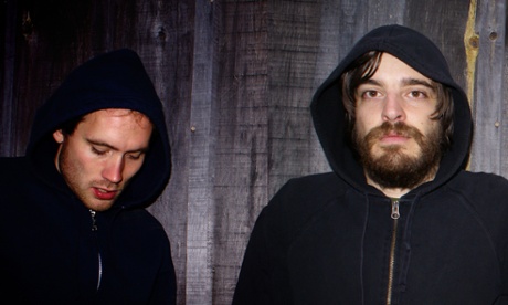 The band members of Holy Fuck, wearing dark hoodies