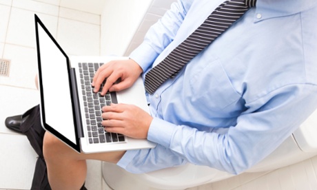 Man sitting on toilet in suit with laptop