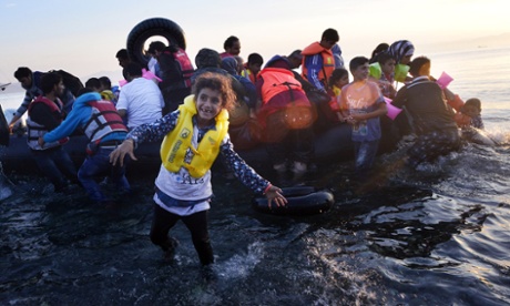 A Syrian child smiles as a group of refugees arrive on the Greek island of Kos