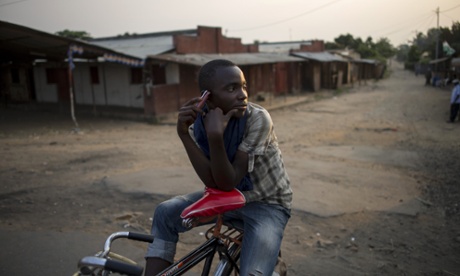 A bicycle taxi-man listens to the news using the radio on his mobile phone while waiting for clients in Bujumbura, Burundi.