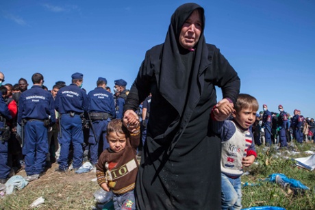 Police surround refugees, many from Syria, on the Serbian-Hungarian border. Photograph: Antonio Olmos