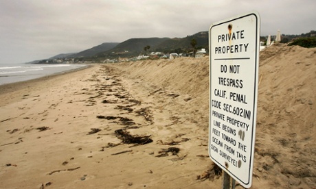 A sign threatens beachgoers with penalties for trespass.