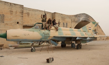Fighters affiliated to al-Qaeda sit on a Syrian warplane after they seized the Abu Duhur military airbase in the northwestern Idlib province, on 9 September 2015.
