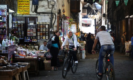 Cyclists pass one another in the historic Souq al-Hamidiyah, in the old city of Damascus.