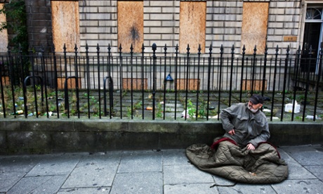 A man begs in front of a boarded up Georgian exterior at the top of Leith Walk in Edinburgh, Scotland.