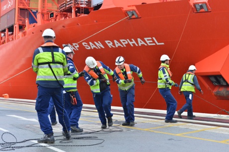 Dockers tie up a ship.