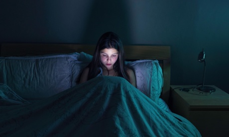 Girl using her mobile phone in bed