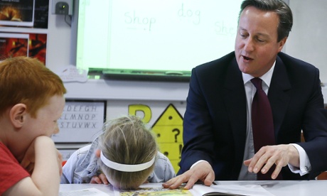 Britain's Prime Minister David Cameron reads a book to Lucy Howarth, 6,    in Westhoughton near Bolton, England, in April 2015. 