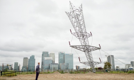 Alex Chinneck with his new sculpture in Greenwich: a giant upside-down pylon, 35m tall